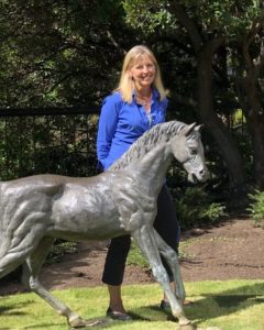 Cheryl Kringle standing next to a horse statue
