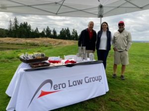 Three people standing next to a swag table at a golf course